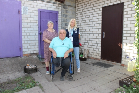 Nahaufnahme von lachenden älteren Frauen im Vordergrund ist angeschnitten eine kleine Karte mit einem Smiley zu sehen.