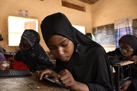 Das Mädchen Malika sitzt im Klassenzimmer und liest Brailleschrift.