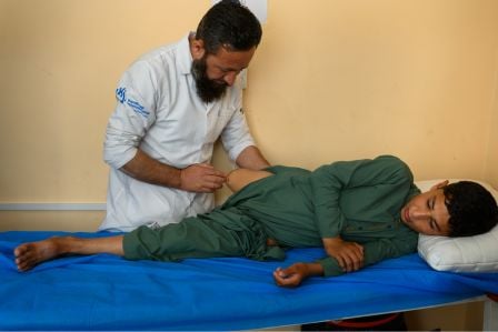 Entminerin von HI aus dem Senegal steht in Ausrüstung auf einem Feld.