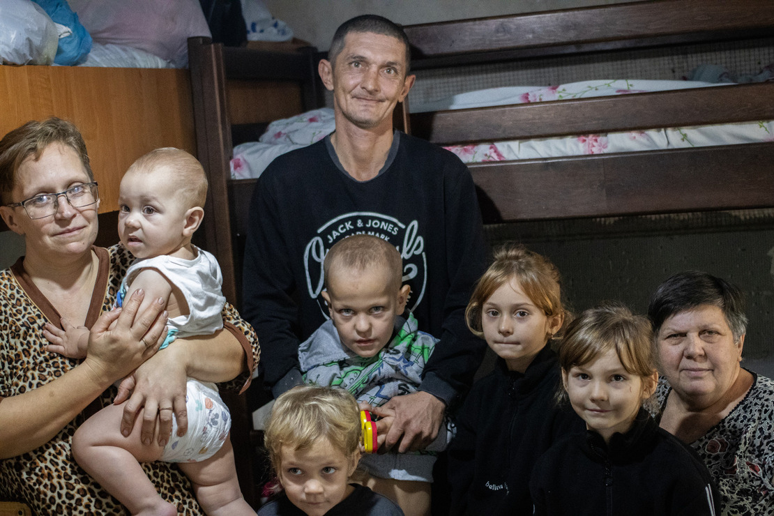 Familie mit fünf Kindern schaut in die Kamera.